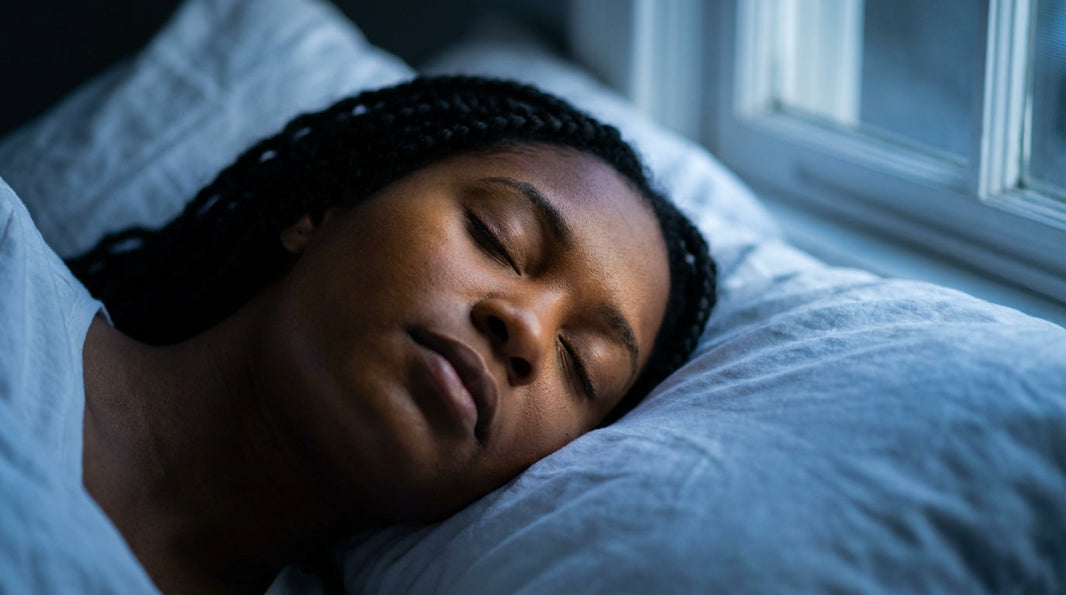 Woman sleeping peacefully in soft blue moonlight, representing the sleep benefits of magnesium glycinate