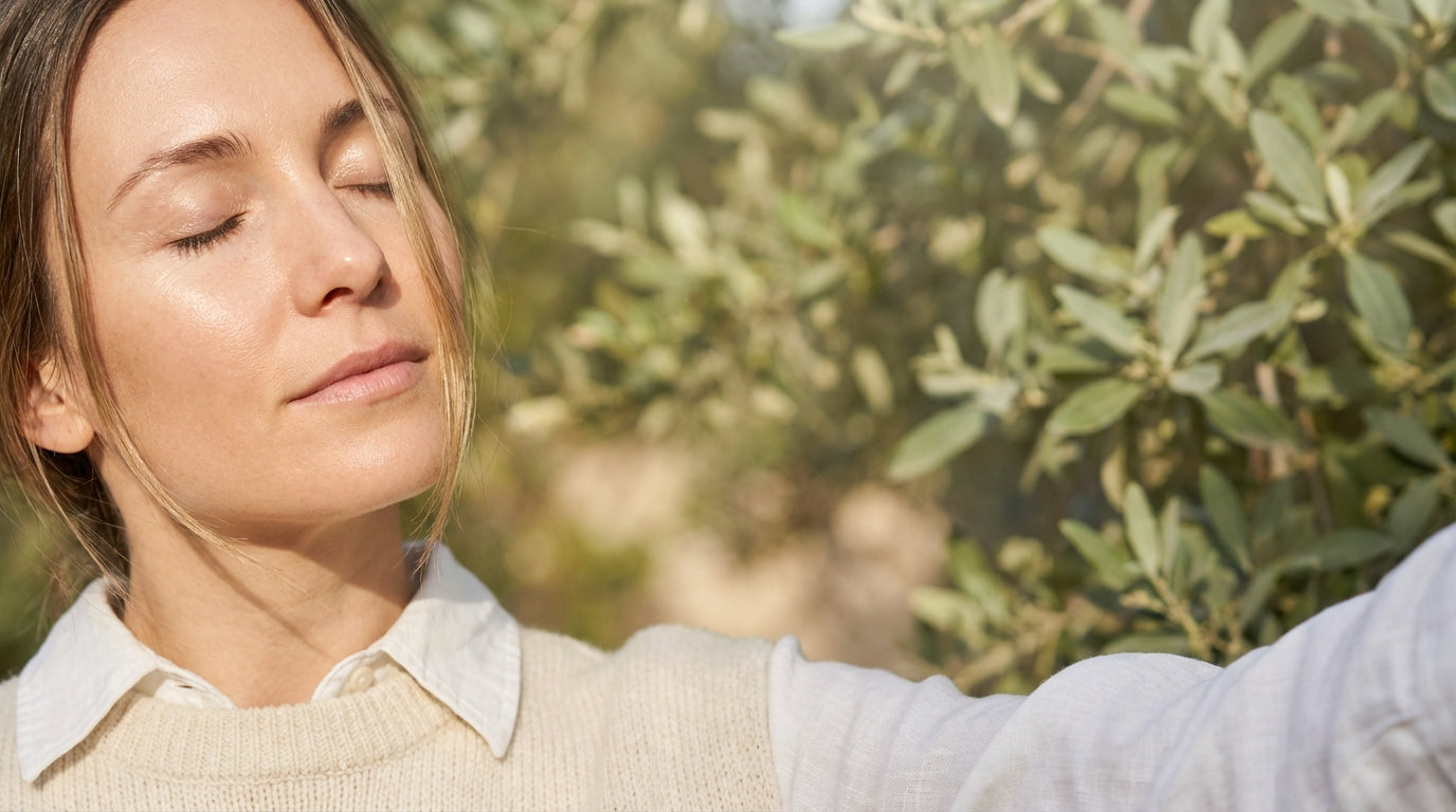 Woman with eyes closed in natural light, representing eye health and wellness